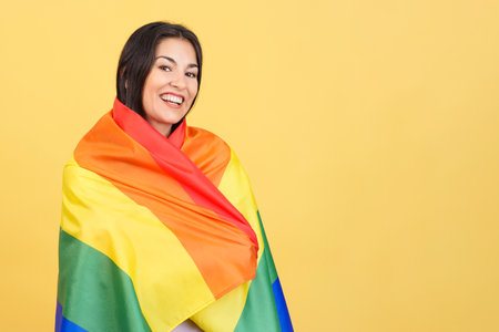 Happy caucasian woman wrapped with a lgbt flagの写真素材