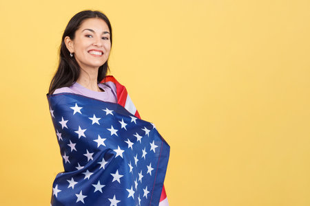 Happy caucasian woman wrapping with a north america national flagの写真素材