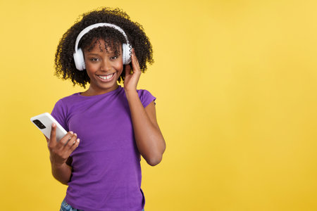 Beauty woman with afro hair listening to music with mobileの写真素材