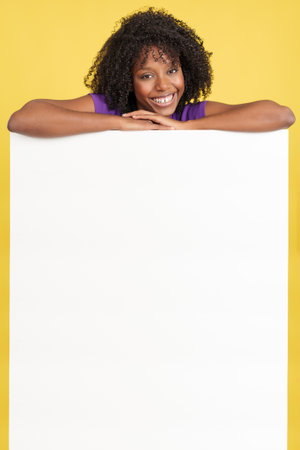 Happy woman with afro hair above a blank panelの写真素材