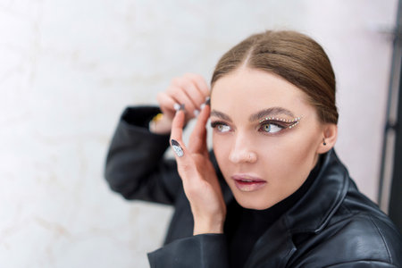 Woman applying instant invisible stickers to the face indoorsの写真素材
