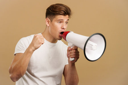 Upset caucasian man yelling using a loudspeakerの写真素材
