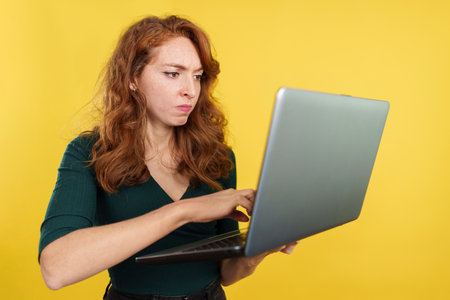 Redheaded woman having a problem with a laptopの写真素材