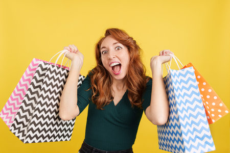 Redheaded woman happy with shopping in the salesの写真素材