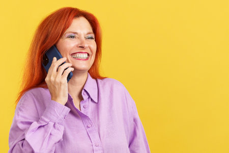 Happy mature woman talking to the mobileの写真素材