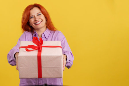 Redheaded mature woman delivering a gift for mothers dayの写真素材