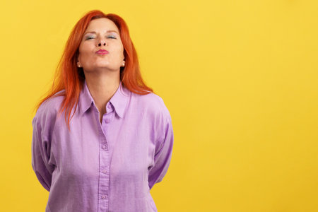Redheaded mature and affectionate mother throwing a kissの写真素材