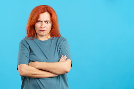 Mature redheaded woman crossing the arms with an angry expressionの写真素材