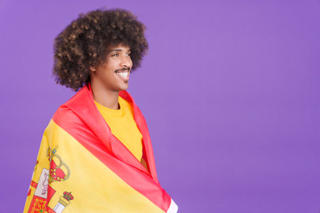 Happy african man wrapping with a spanish flagの写真素材