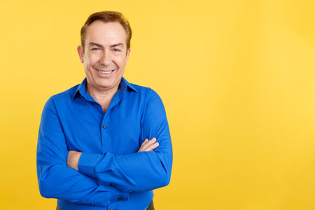 Mature man smiling at the camera standing with arms crossedの写真素材