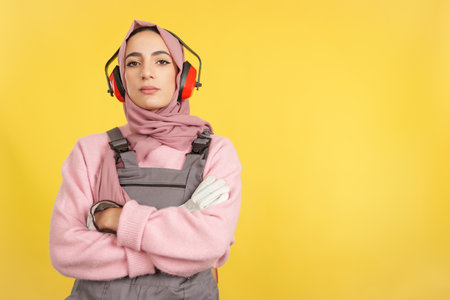 Serious muslim female carpenter in work uniform looking at cameraの写真素材