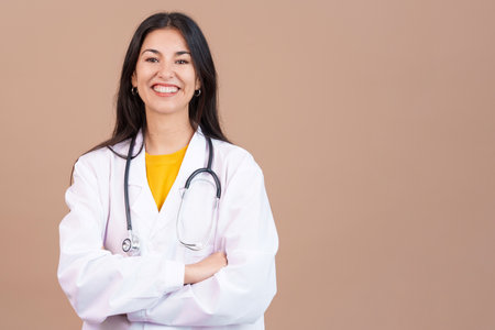 Caucasian female doctor smiling at the camera with arms crossedの写真素材