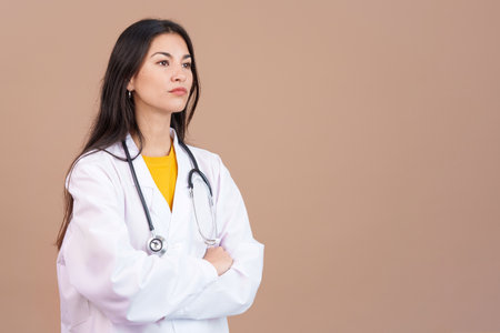 Serious female doctor with arms crossed looking awayの写真素材