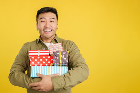 Happy chinese man holing many colorful giftsの写真素材