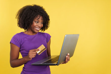 Woman with afro hair shopping online with a laptopの写真素材