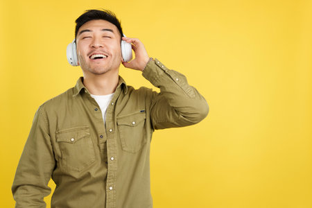 Relaxed chinese man listening to music with headphonesの写真素材