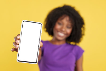 Hand of afro woman with mobile with a blank screenの写真素材