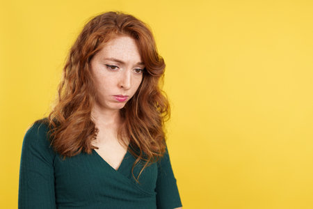 A depressed beauty redheaded woman looking downの写真素材