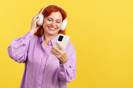 Mature woman listening to music using a mobile phoneの写真素材