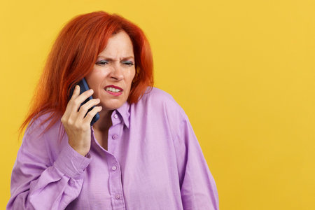 Angry redheaded mature woman talking to the mobileの写真素材