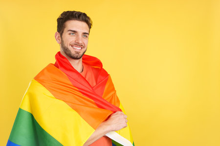 Distracted caucasian man wrapped with a lgbt flagの写真素材