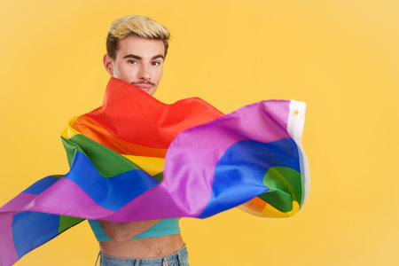 Happy gay man waving a lgbt rainbow flagの写真素材