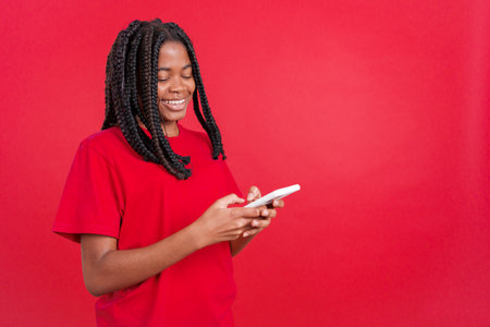 Happy african woman smiling while using the mobile
