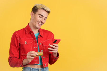 Happy gay man using the mobile phone to shopping onlineの写真素材