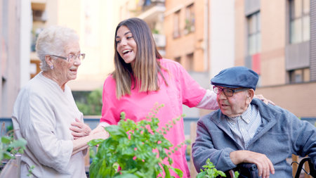 Caregiver singing with seniors in the terrace of a geriatricsの写真素材
