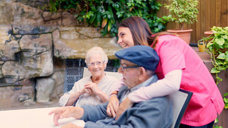 Nurse and seniors talking and laughing in a geriatric