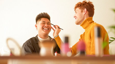 Cosmetic on a shelf while gay couple applying make upの写真素材