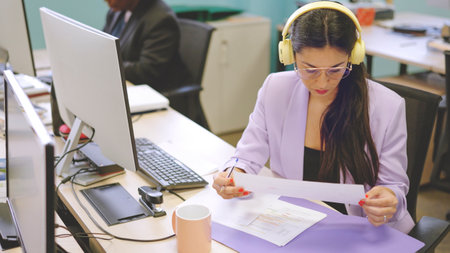Concentrated woman reading a financial report in a coworkingの写真素材