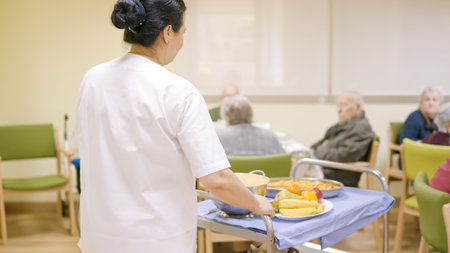 Cook entering with food to the dining room of geriatricの写真素材