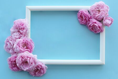 Beautiful delicate pastel background with white frame and pink rosesの写真素材
