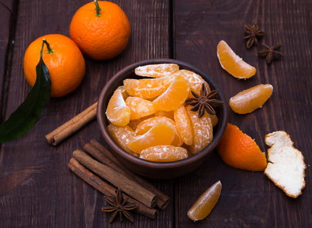 Tangerines with cinnamon stick and anisetree on old wooden tableの写真素材