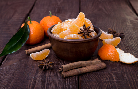 Tangerines with cinnamon stick and anisetree on old wooden tableの写真素材