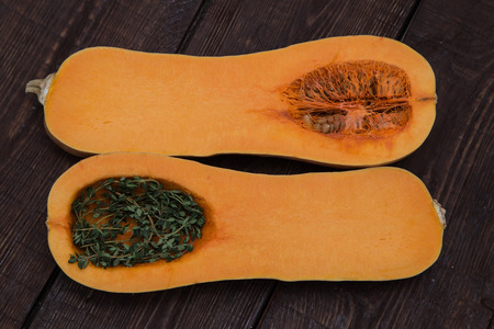 pumpkin and thyme on a dark wooden backgroundの写真素材