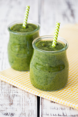Green smoothie with apple, banana and spinach on a light backgroundの写真素材