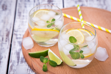 Fresh cocktail with soda, lime and lemon on a wooden background.の写真素材