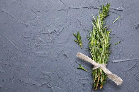 Sprigs of rosemary tied with string on a dark gray background.の写真素材