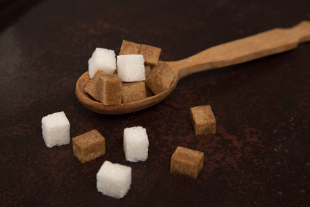 brown and white Sugar cubes on the wooden spoon.の写真素材