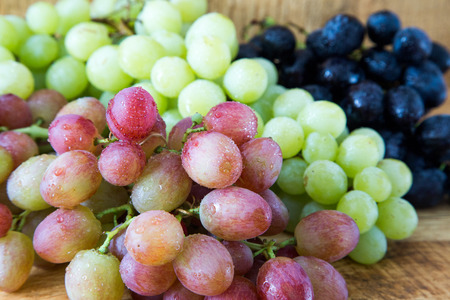 Grapes on a wooden table. White, pink and black grapesの写真素材