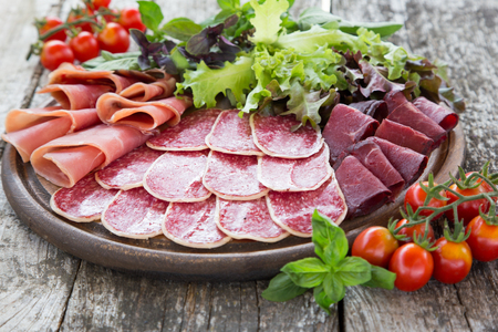 Antipasto with ham, salami and bresaola. tomato and basil. selective focus.の写真素材