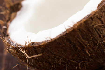 Half of ripe coconut on wooden background.の写真素材