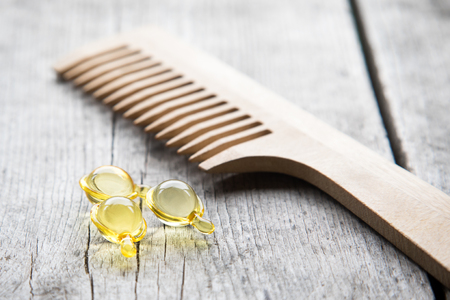 Hair nurishment. vitamin serum capsule on wooden background.の写真素材