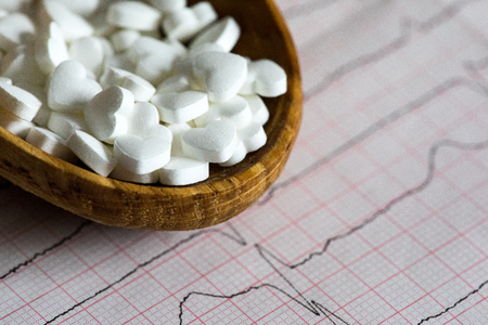 Cardiology. Macro of ECG graph and cardio pills. Pills as a heart.の写真素材