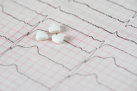 Cardiology. Macro of ECG graph and cardio pills. Pills as a heart.の写真素材