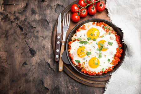Tasty and Healthy Shakshuka in a Frying Pan. Fried eggs with tomatoes, bell pepper, vegetables and herbs. Middle eastern traditional dishの写真素材