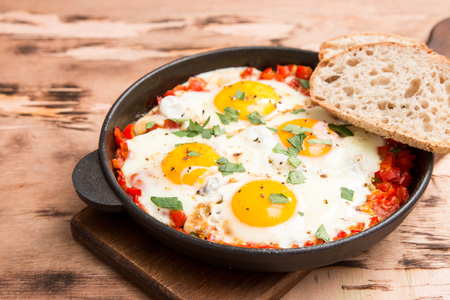 Tasty and Healthy Shakshuka in a Frying Pan. Fried eggs with tomatoes, bell pepper, vegetables and herbs. Middle eastern traditional dishの写真素材
