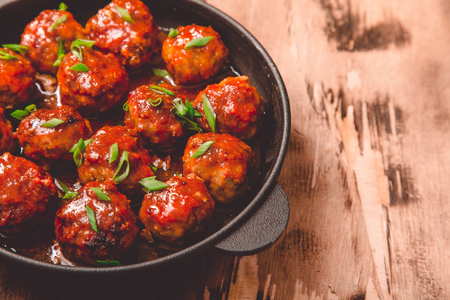Meatballs in sweet and sour tomato sauce. Homemade roasted beef meatballs in cast-iron skillet.の写真素材